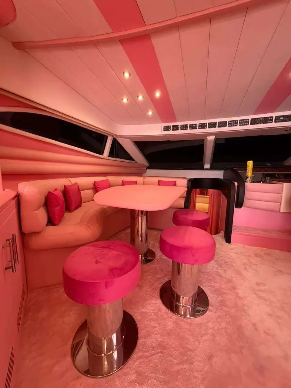Pink dining corner with bar stools inside the Pink Yacht's salon
